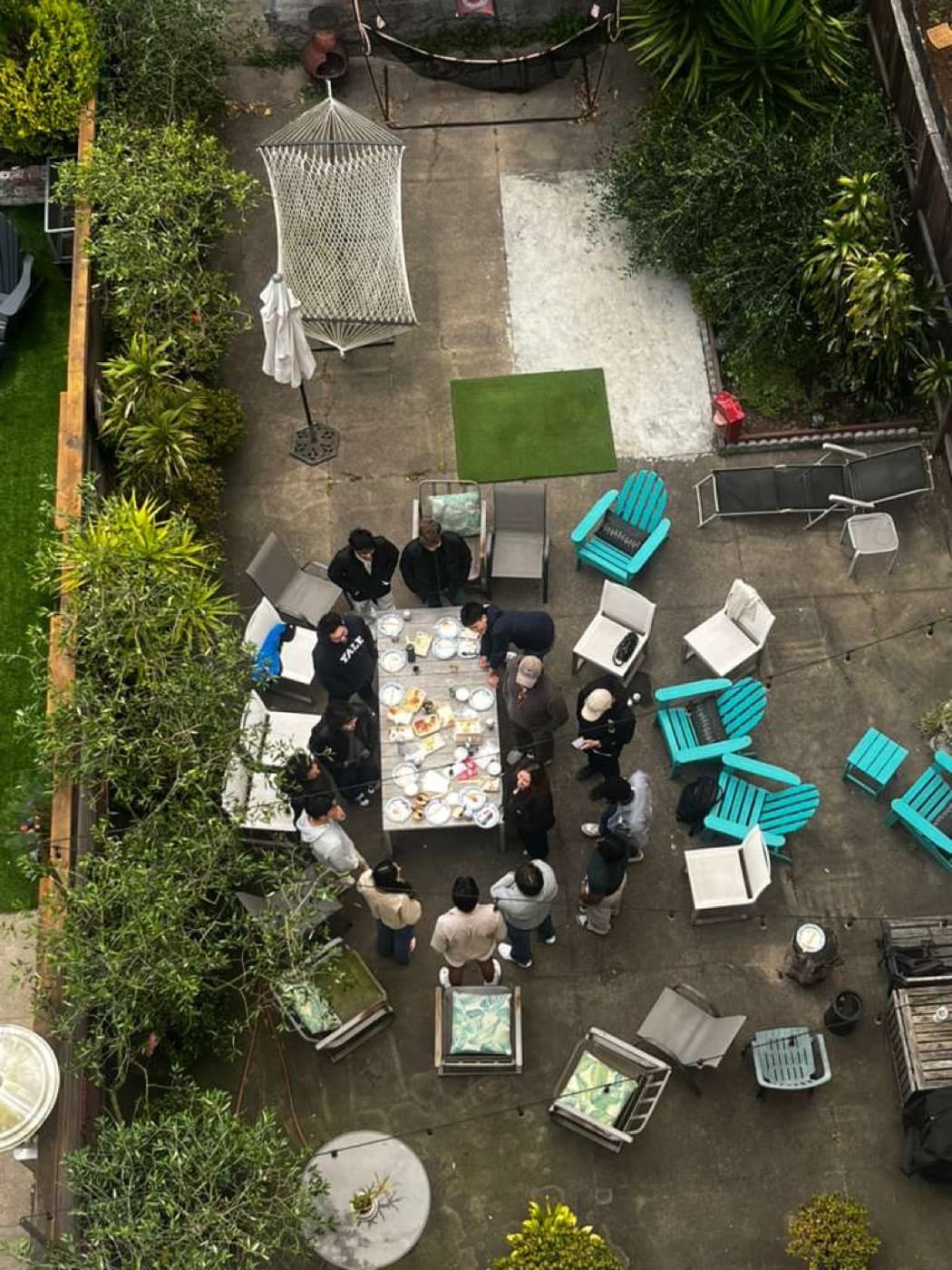 Aerial view of the hacker house backyard, founders around a brunch table